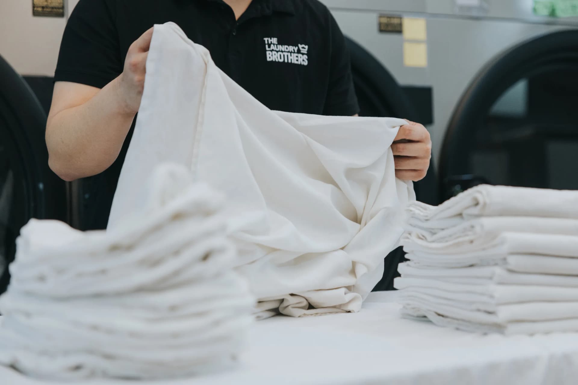 Laundry Brothers team member smiling at the facility with tablet in hand.