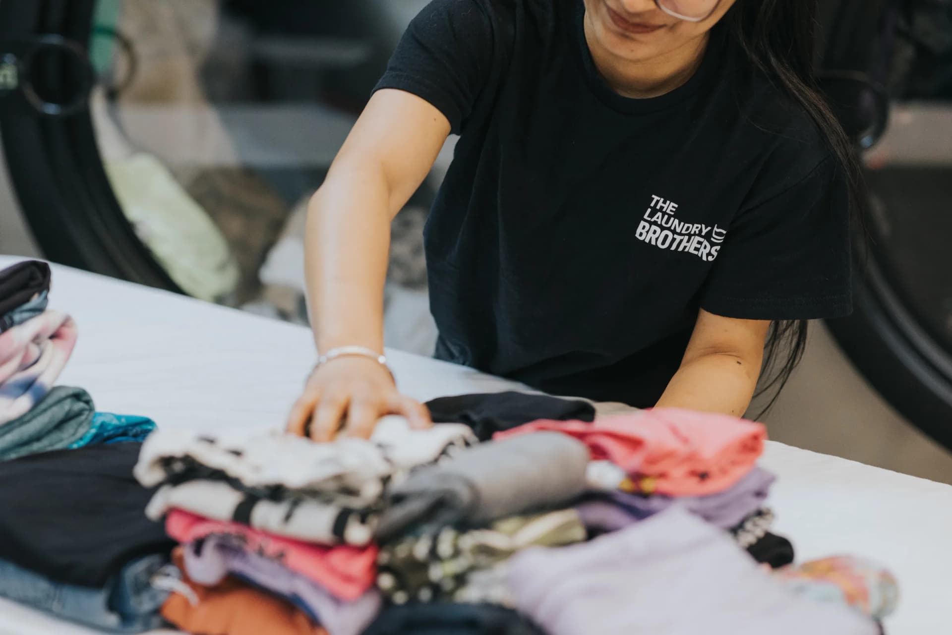 Team member doing a quality check on clean laundry at the facility.
