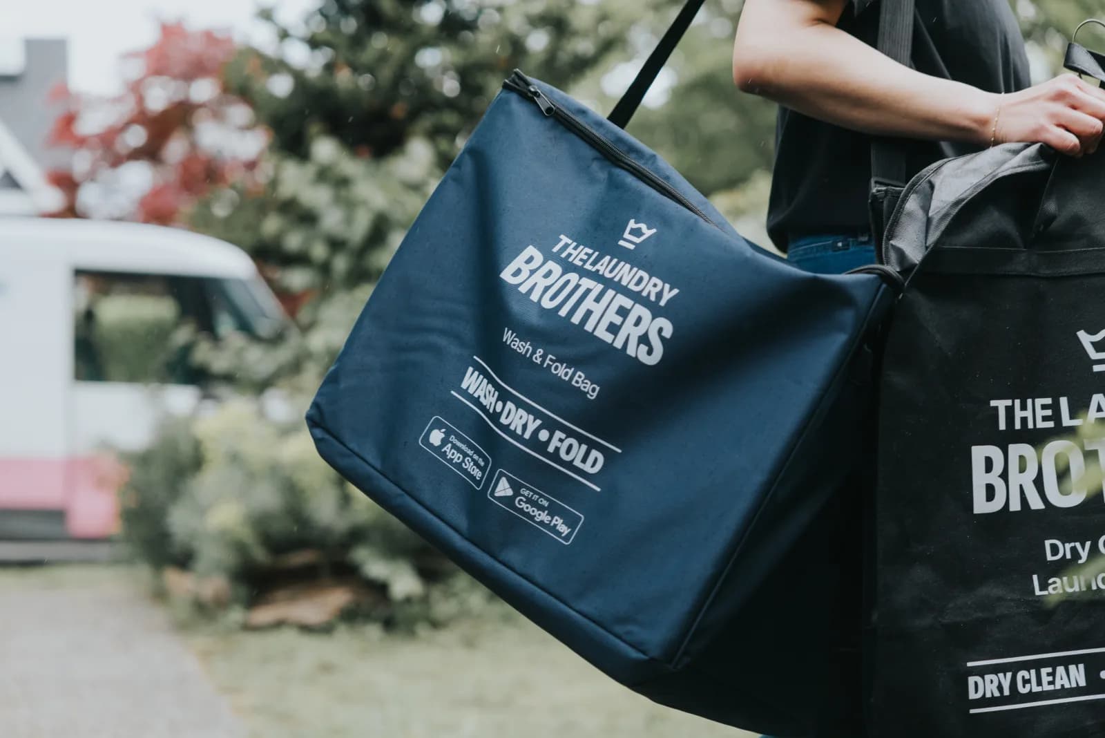 A Laundry Brothers driver delivering a wash & fold bag at a Burnaby doorstep.