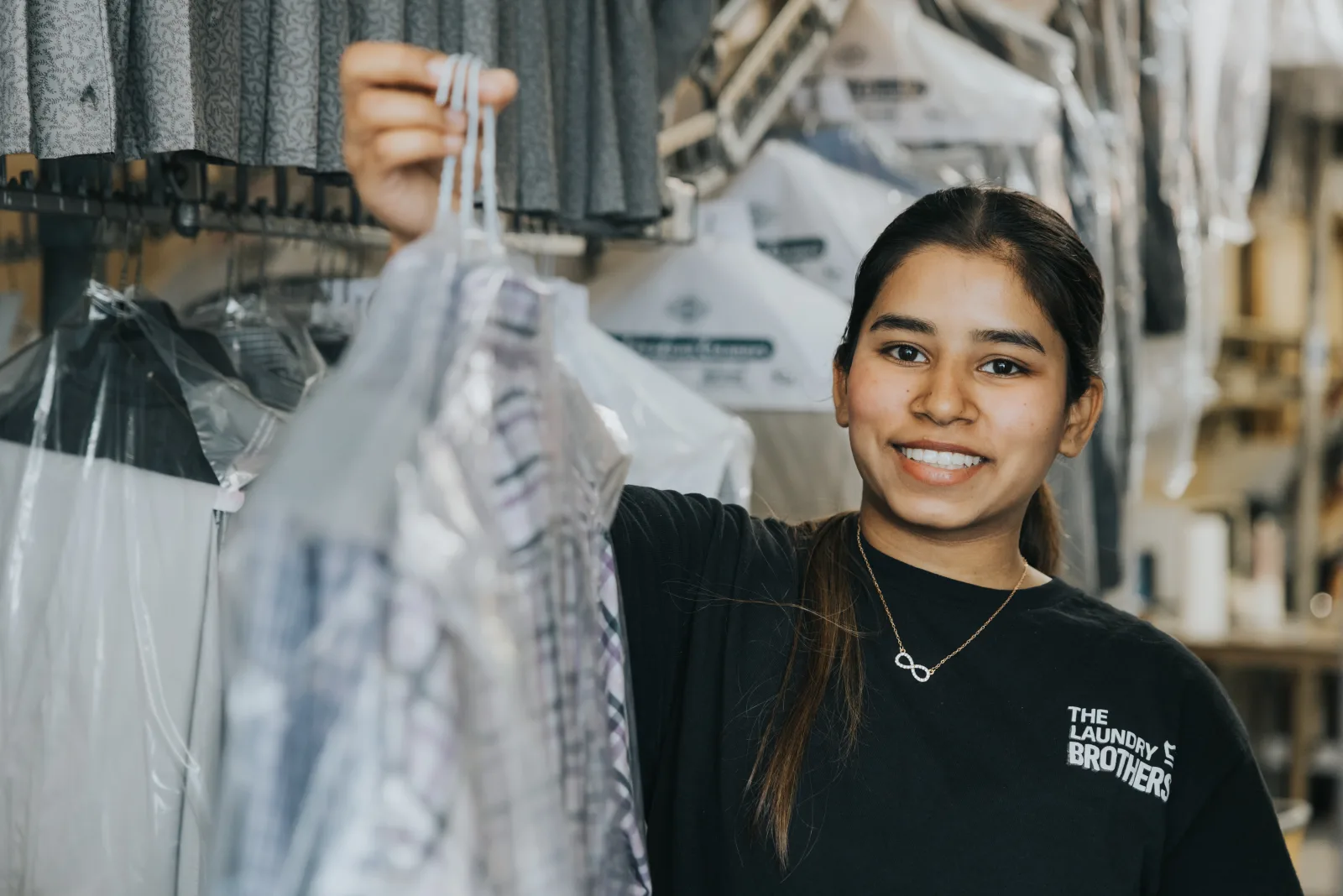A Laundry Brothers team member with a freshly cleaned garment for a Burnaby customer.