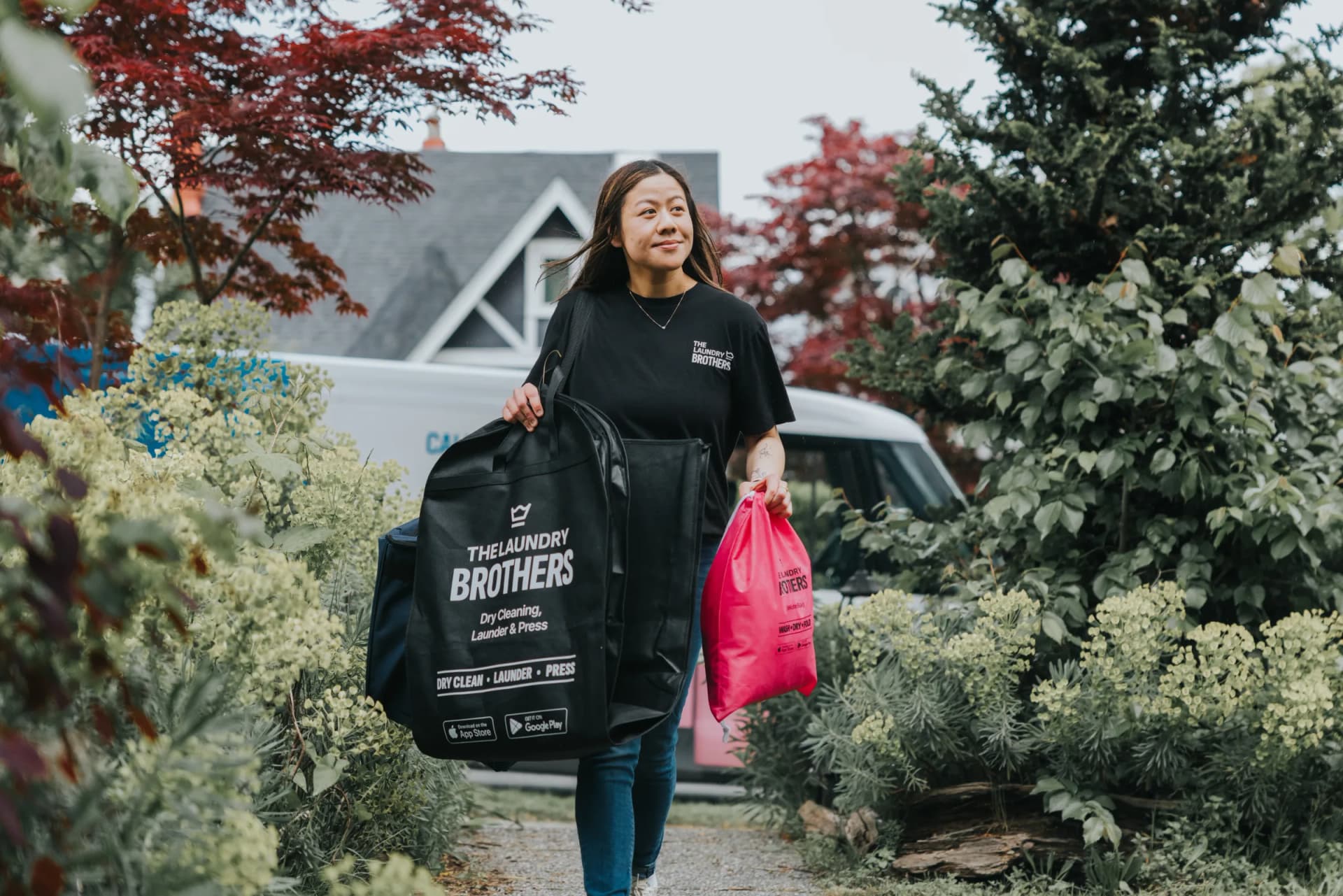 A Laundry Brothers driver carrying the wash & fold bag and dry cleaning bag, showing all service options.